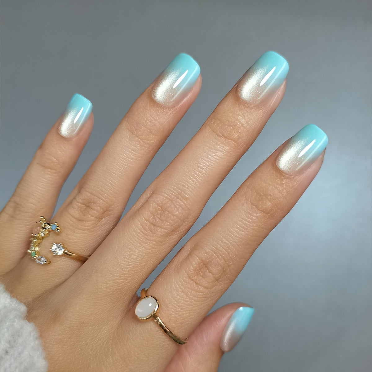 Arctic Mist short squoval press-on nails worn on a hand