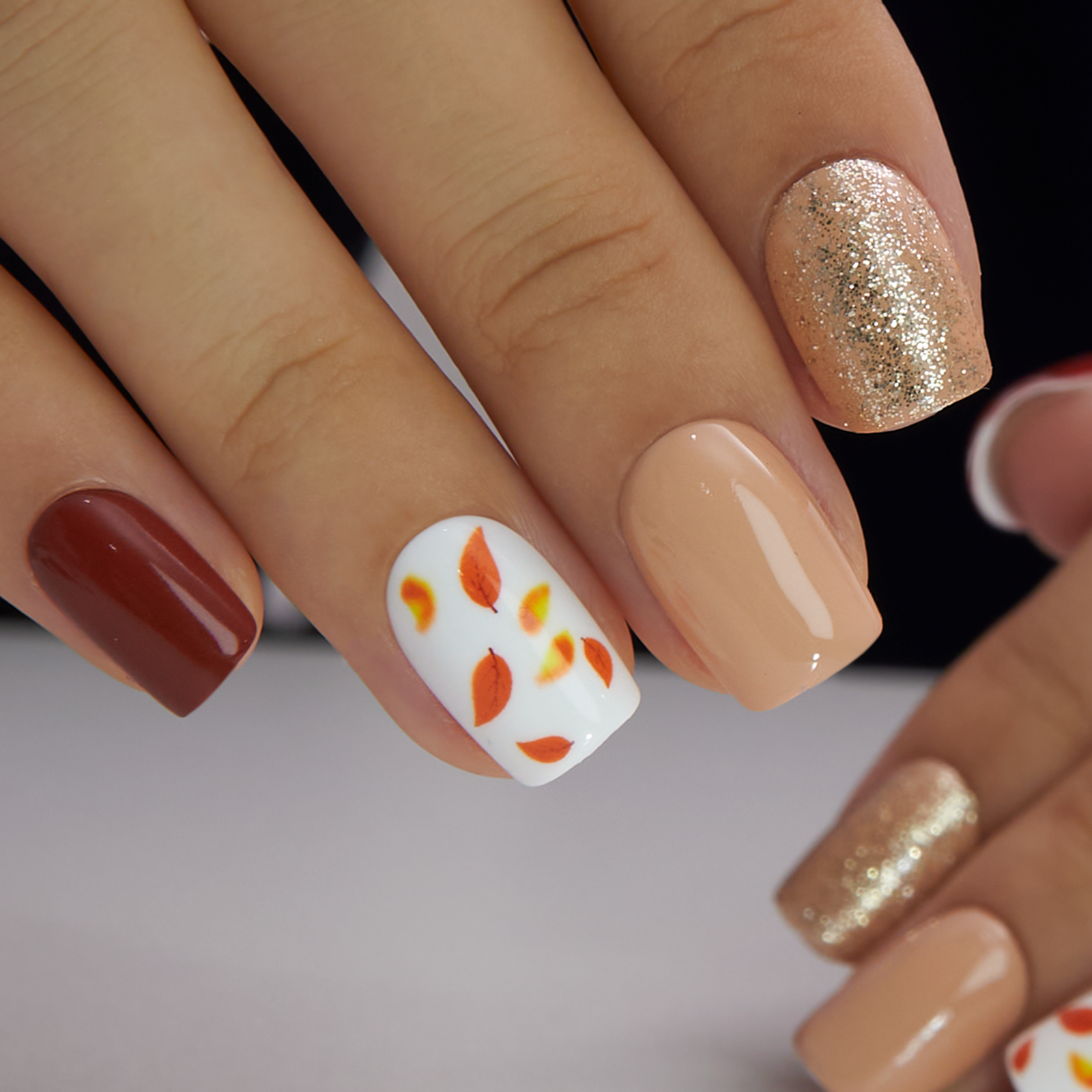 Autumn Whisper short squoval press-on nails worn on a hand