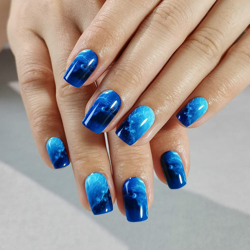 Blue Cosmos medium squoval press-on nails worn on a hand
