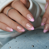 Blush Dot French short almond press-on nails worn on a hand