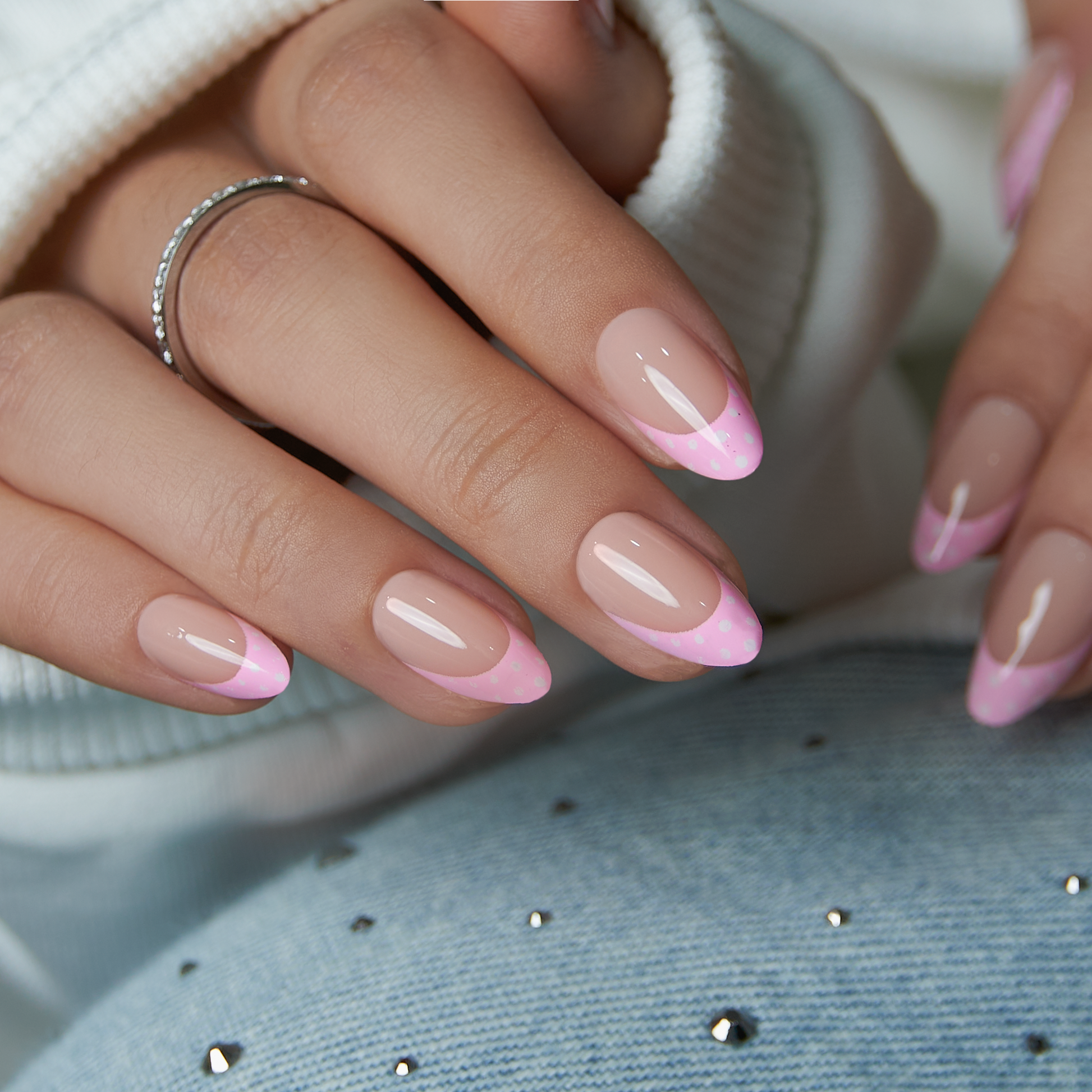 Blush Dot French short almond press-on nails worn on a hand