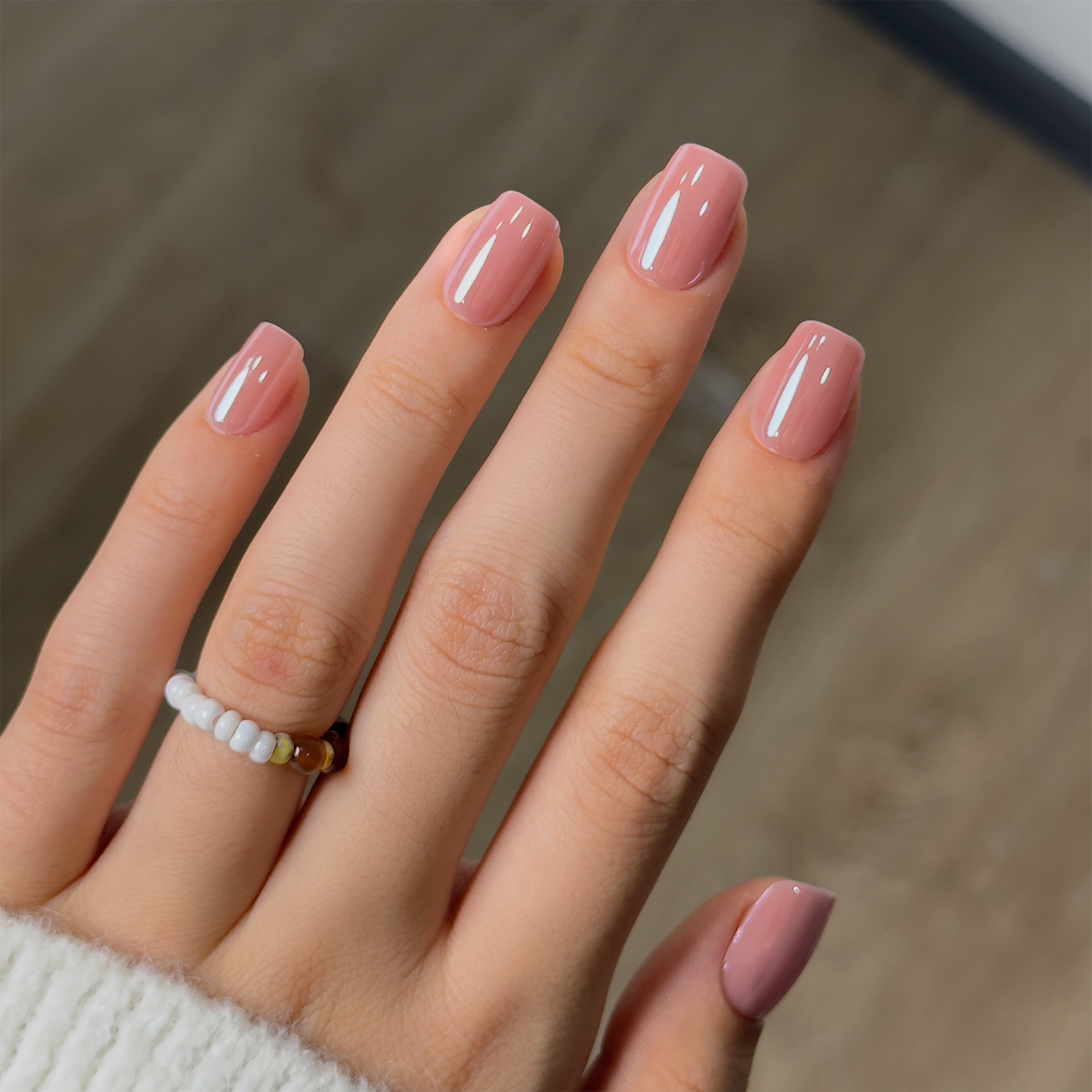 Blush Glossy short squoval press-on nails worn on a hand