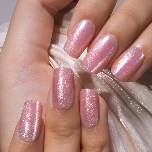 Blush Whisper medium squoval press-on nails worn on a hand