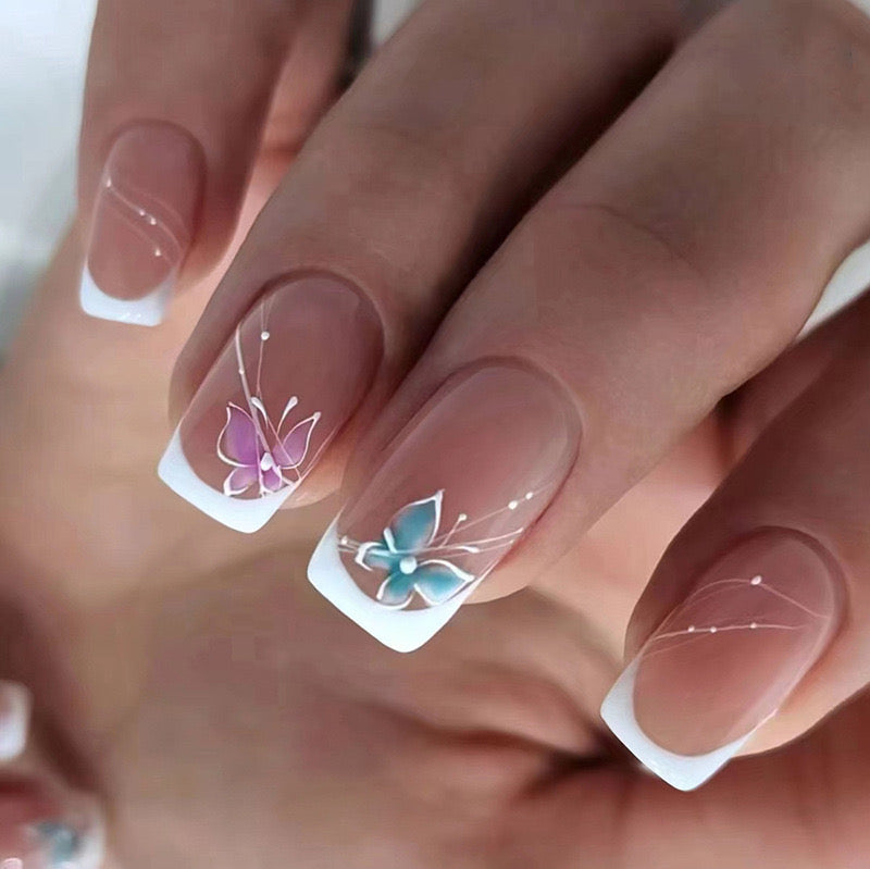 Butterfly French medium squoval press-on nails worn on a hand
