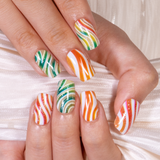 Candy Swirl medium squoval press-on nails worn on a hand