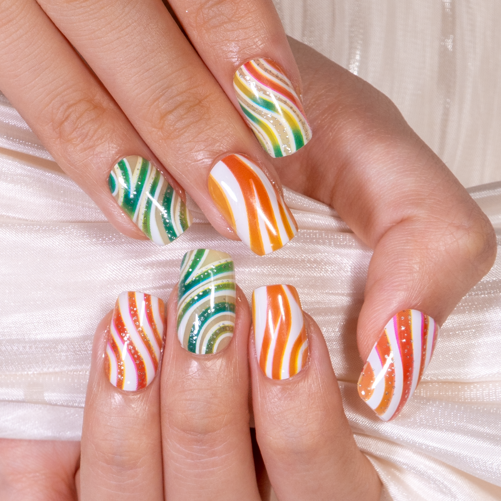Candy Swirl medium squoval press-on nails worn on a hand