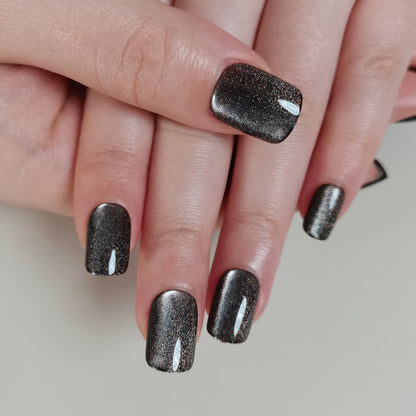 Charcoal Glitter short squoval press-on nails worn on a hand