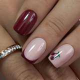 Cherry Blush short squoval press-on nails worn on a hand