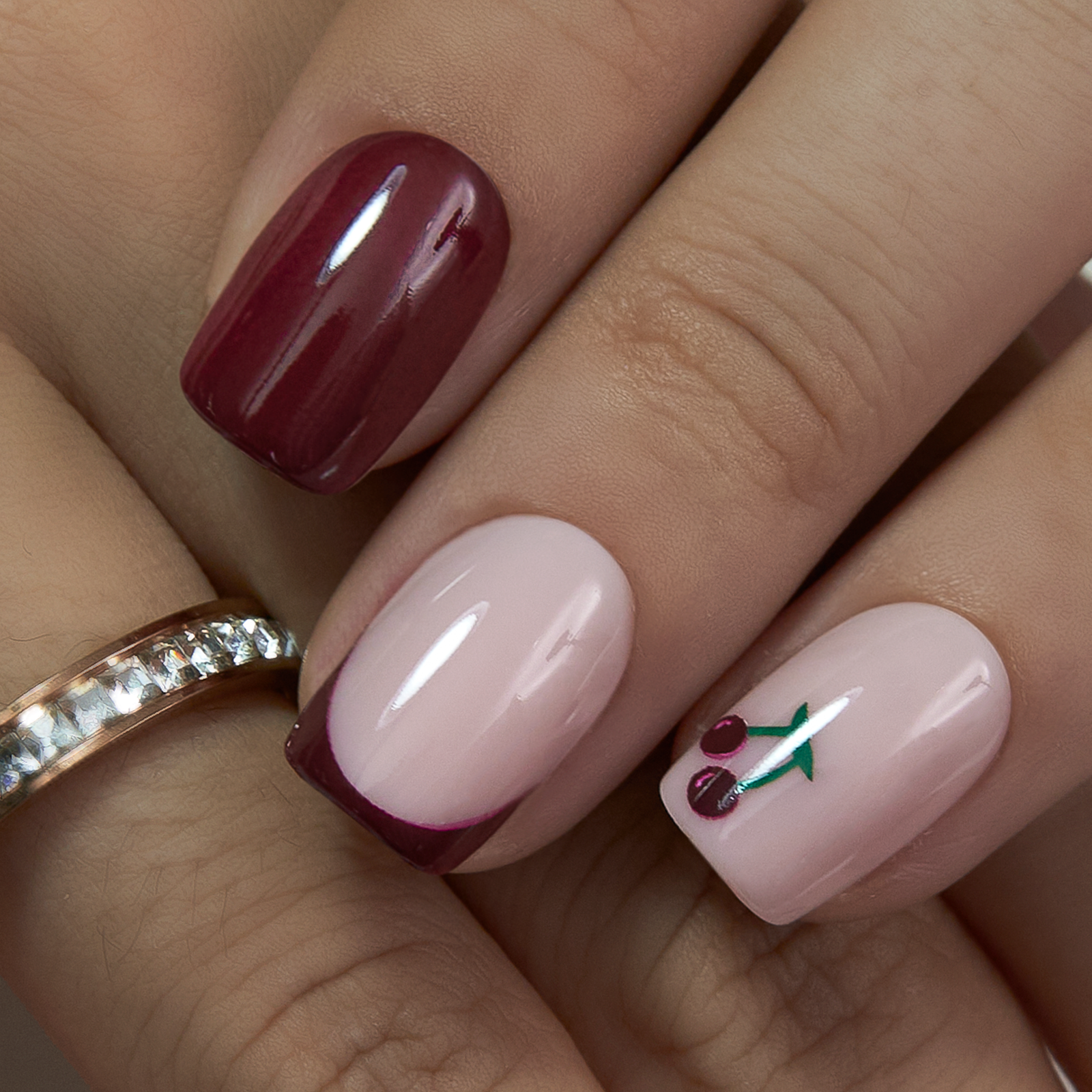 Cherry Blush short squoval press-on nails worn on a hand