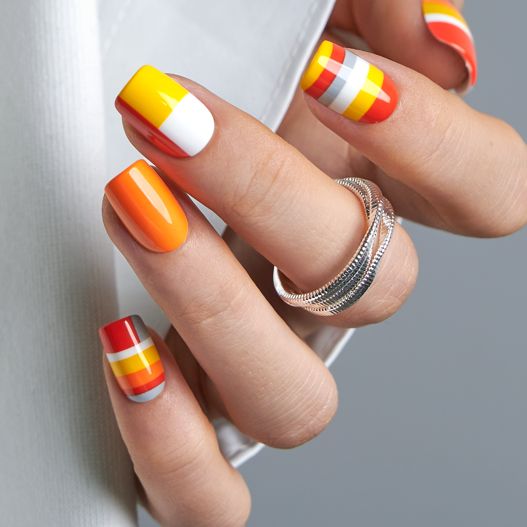 Citrus Pop short squoval press-on nails worn on a hand