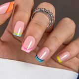 Colorful French short squoval press-on nails worn on a hand