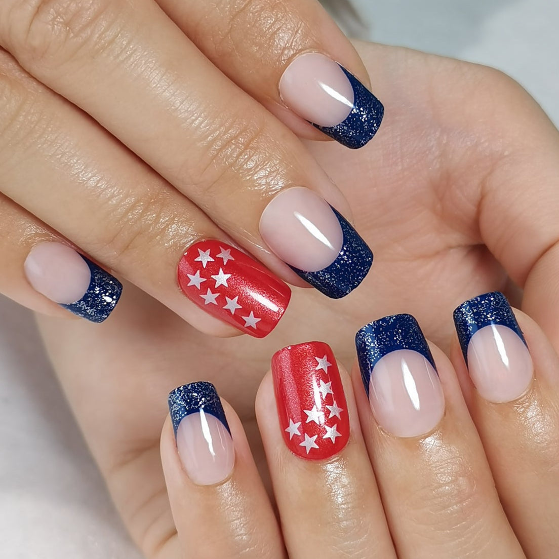 Colorful Stars short squoval press-on nails worn on a hand