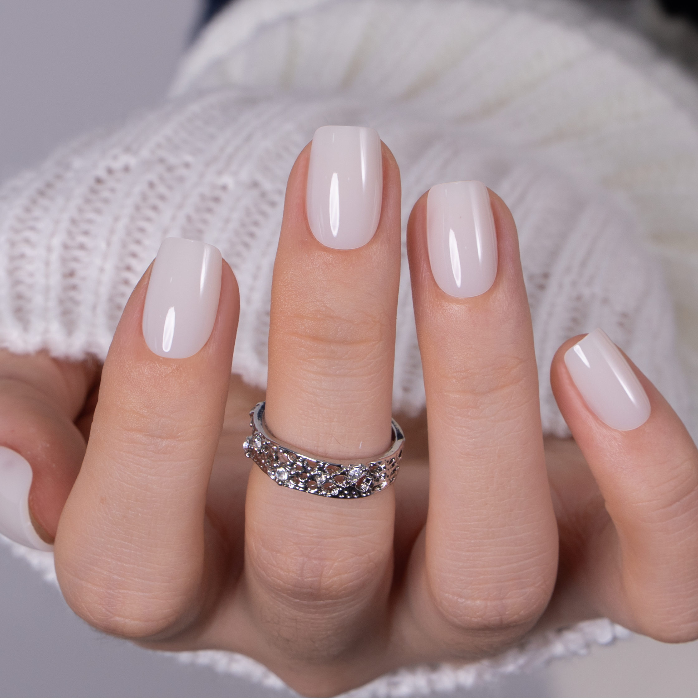 Crystal Blanc short squoval press-on nails worn on a hand