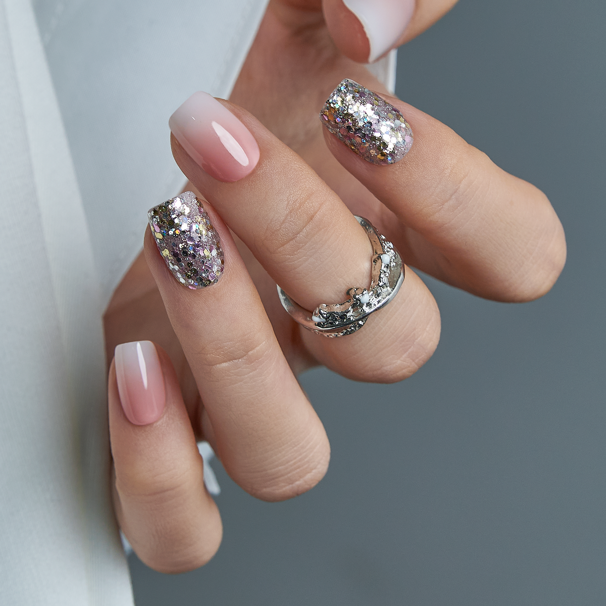 Crystal Dust short squoval press-on nails worn on a hand