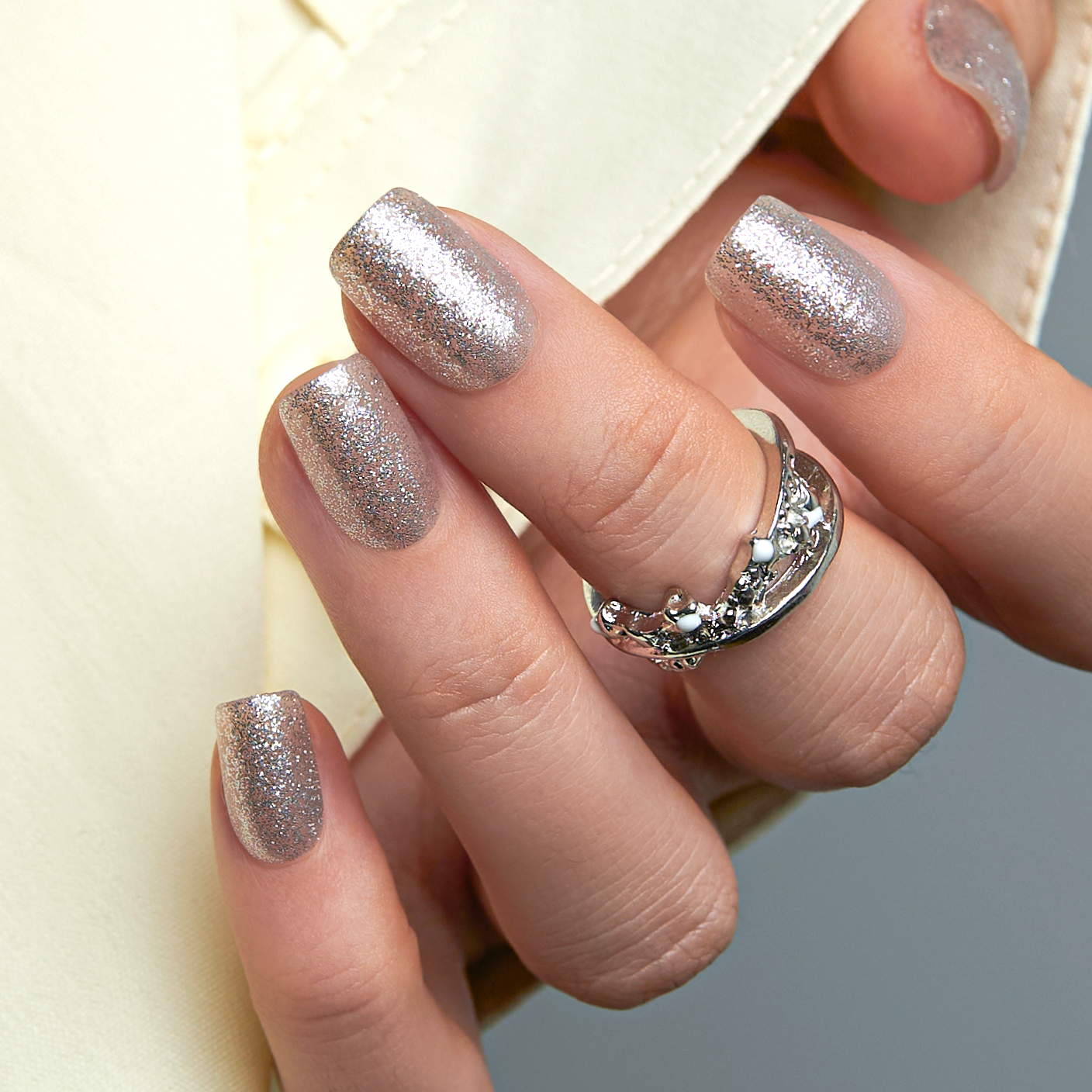 Dazzling Galaxy short squoval press-on nails worn on a hand