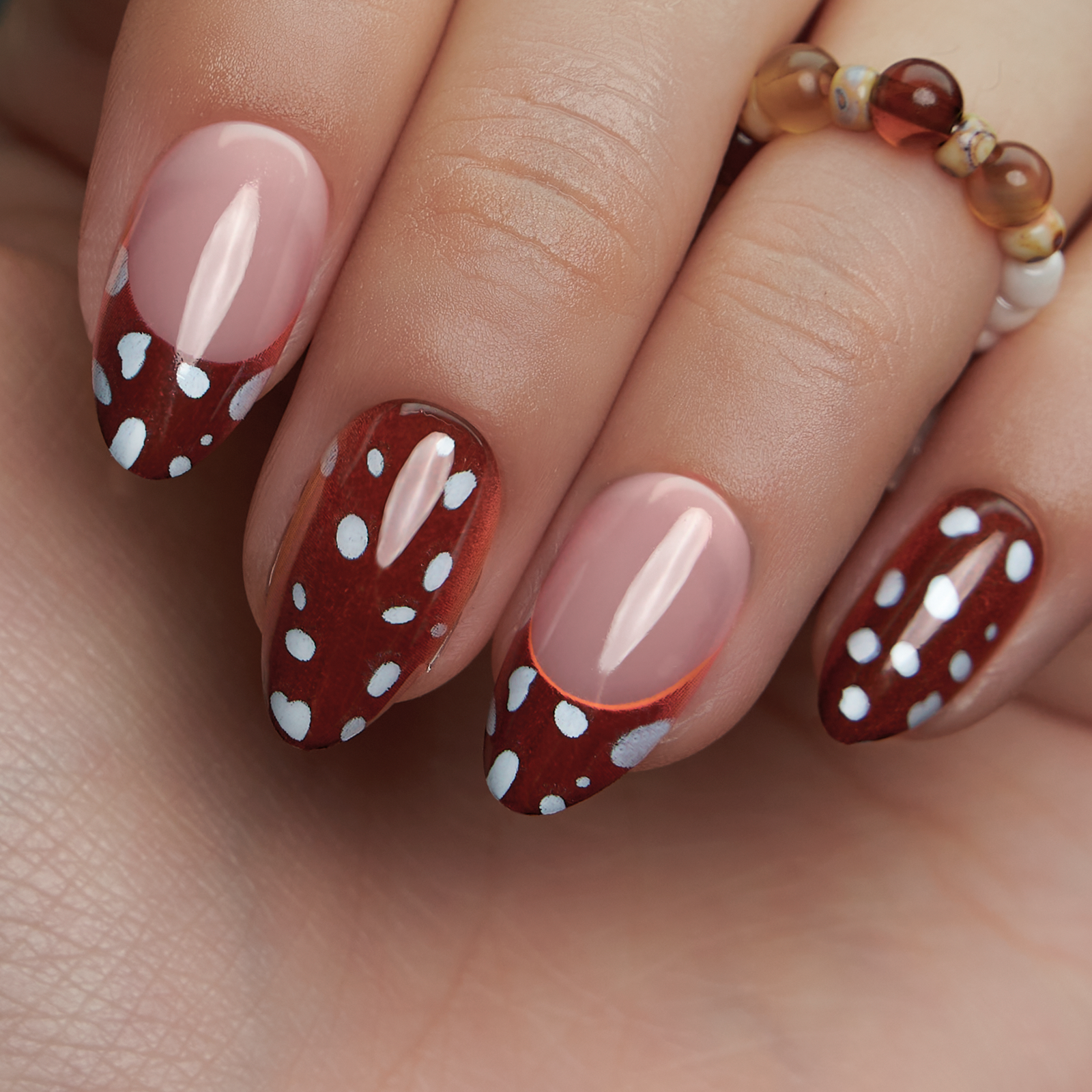 Dotty Delight short almond press-on nails worn on a hand