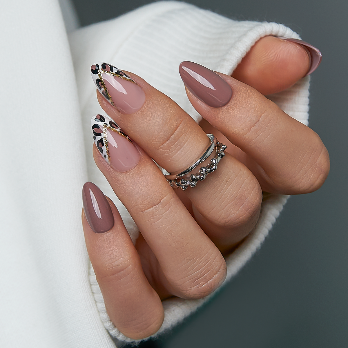 Elegant Leopard short almond press-on nails worn on a hand
