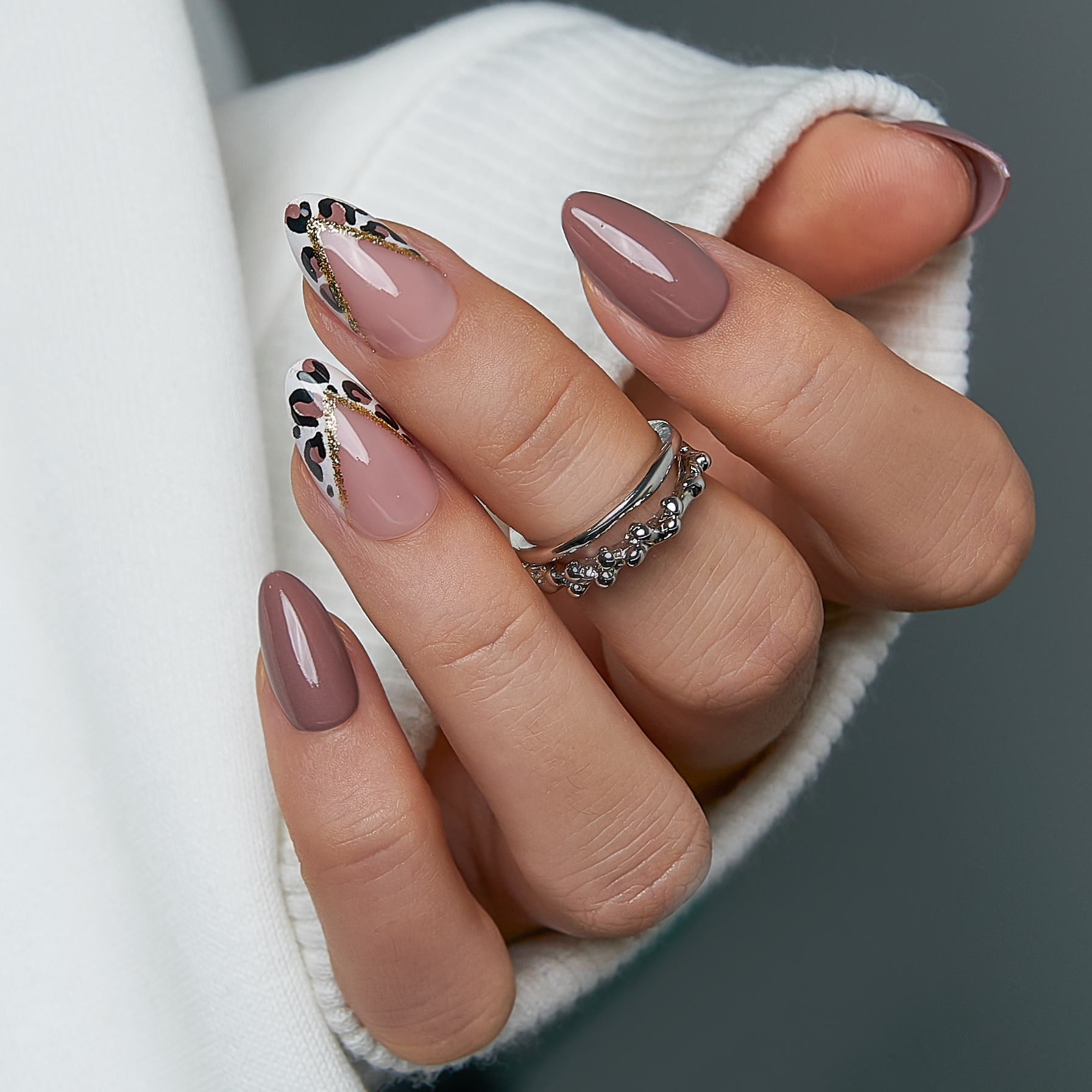 Elegant Leopard short almond press-on nails worn on a hand