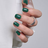 Emerald Muse Rs squoval press-on nails worn on a hand
