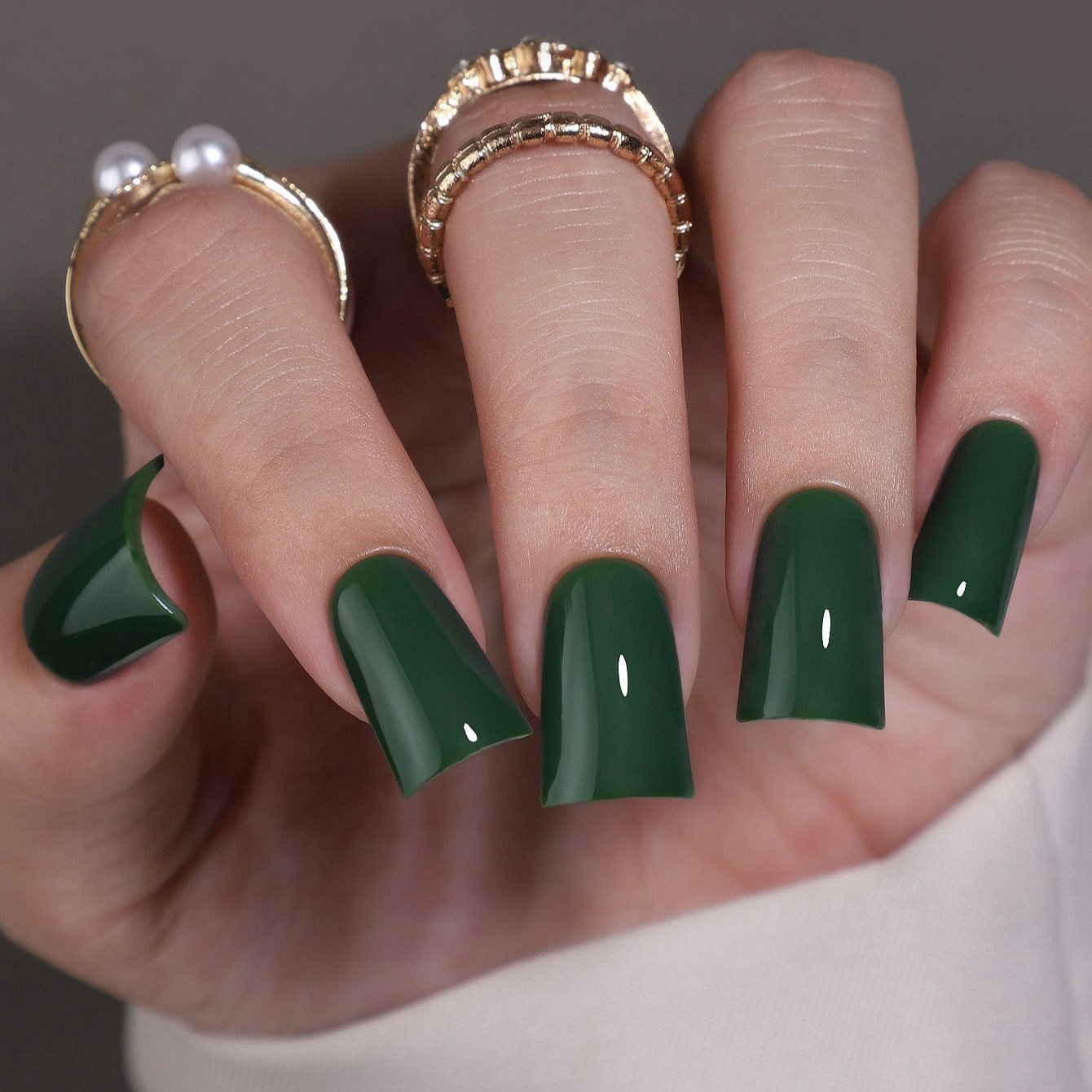 Emerald Pure M Duckbill press-on nails worn on a hand