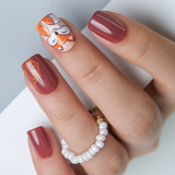Fox And Foliage short squoval press-on nails worn on a hand