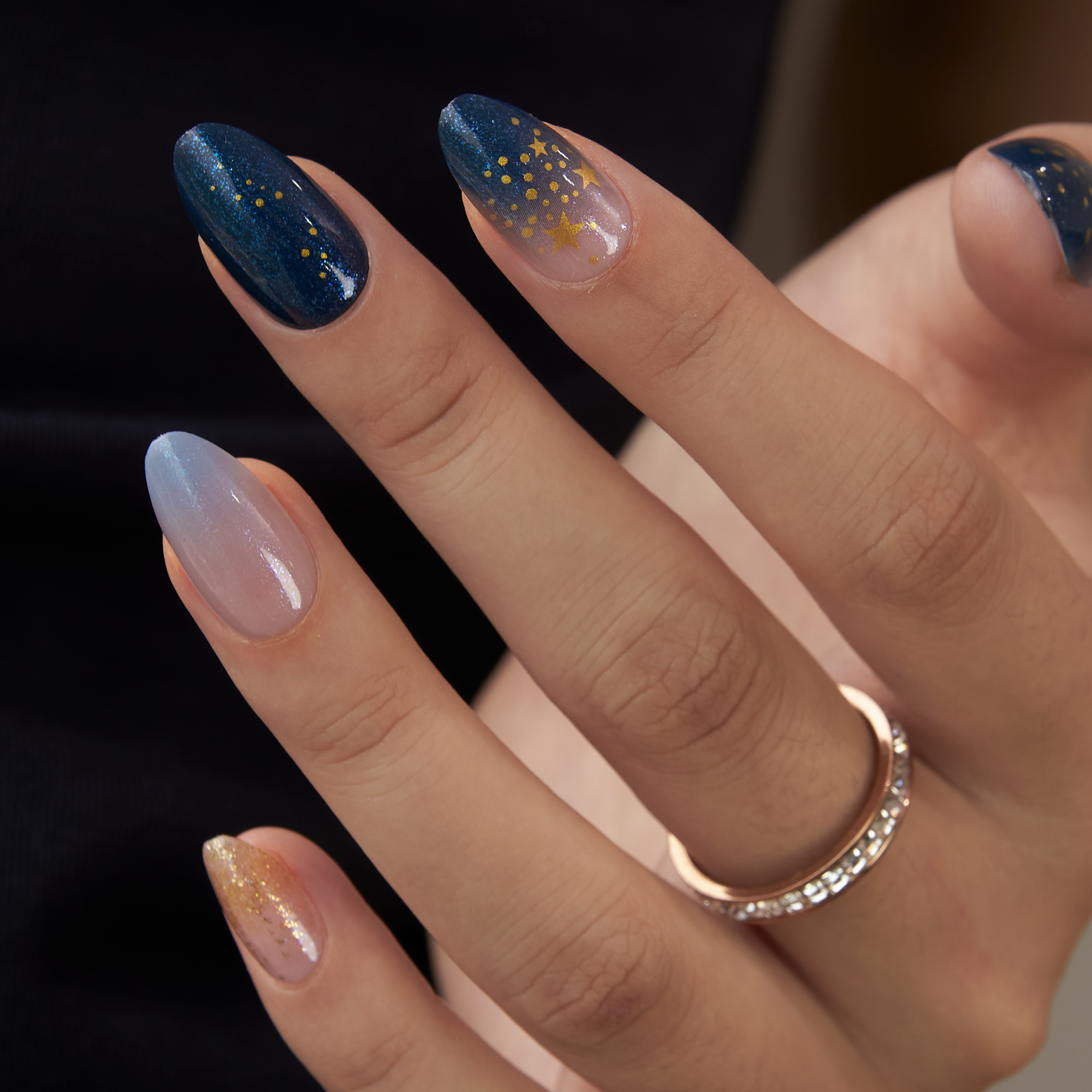 Galaxy Glow Muse short almond press-on nails worn on a hand