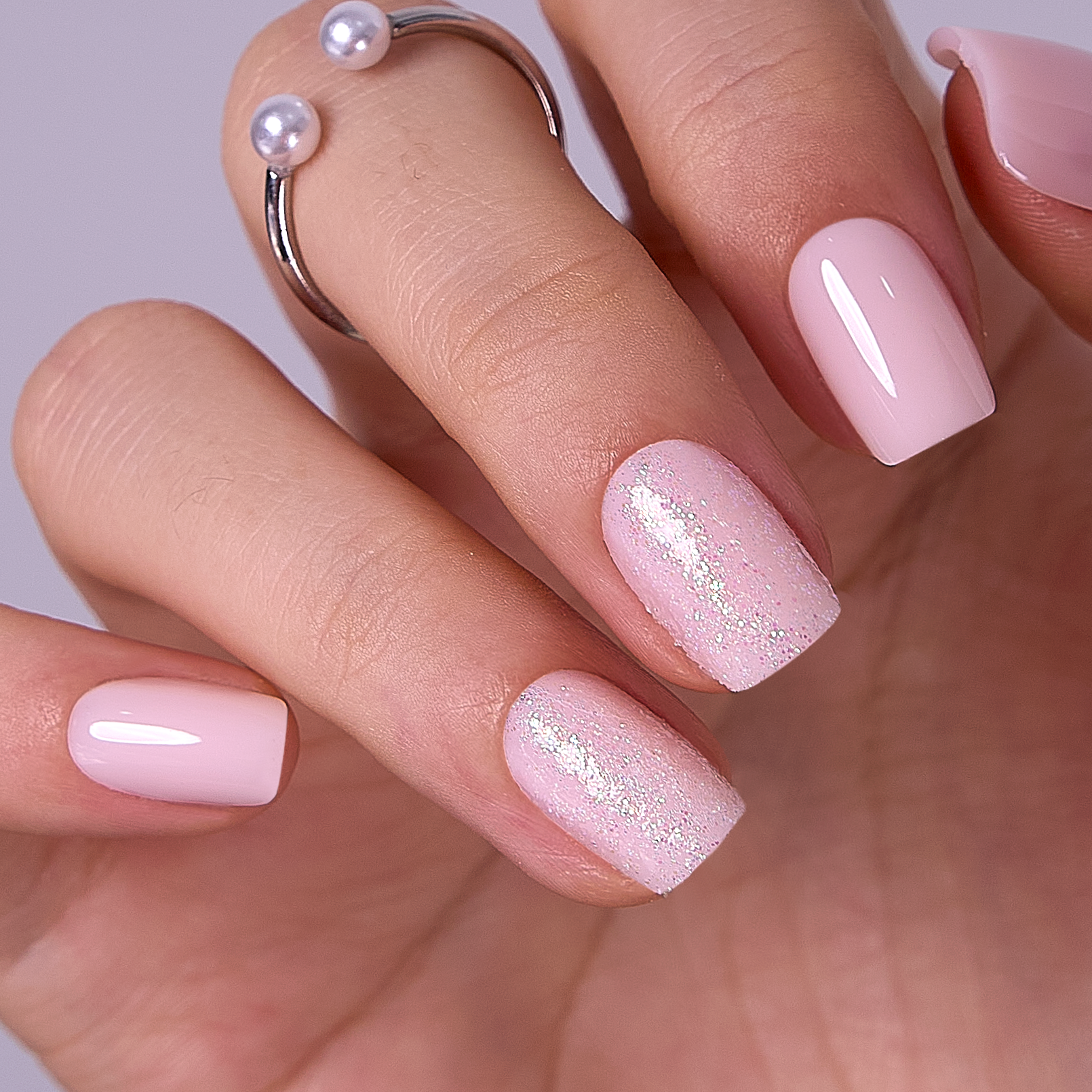 Glitter Ballet short squoval press-on nails worn on a hand