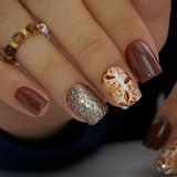 Golden Mocha short squoval press-on nails worn on a hand