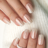 Golden Veil medium squoval press-on nails worn on a hand