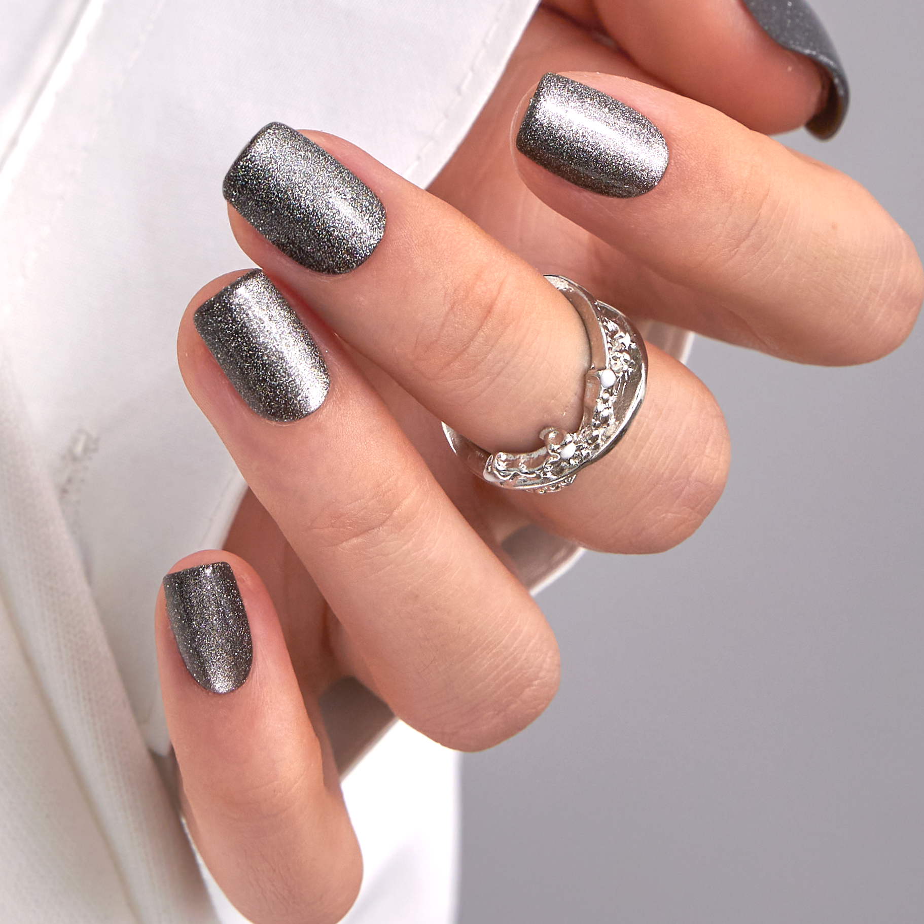 Gray Sparkle short squoval press-on nails worn on a hand