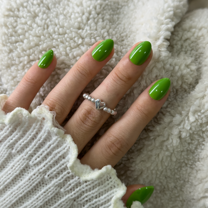 Green Muse Rs almond press-on nails worn on a hand