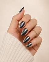 Gunmetal Glow medium almond press-on nails worn on a hand