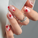 Heart Polka short squoval press-on nails worn on a hand