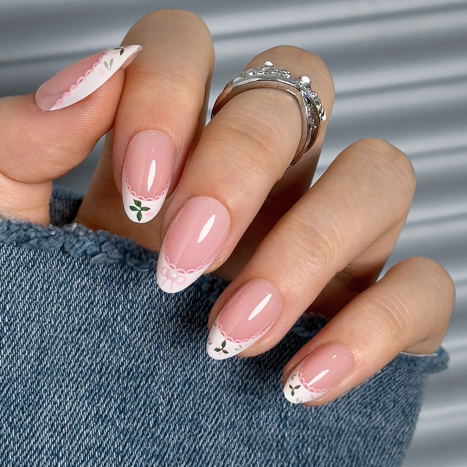Lace Bloom short almond press-on nails worn on a hand
