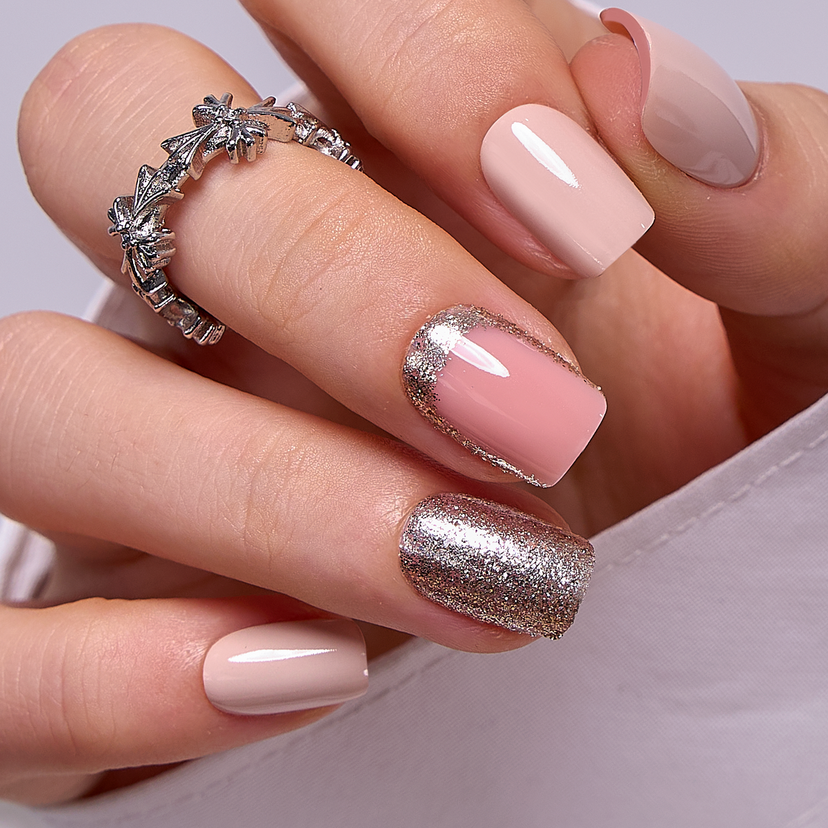 Light Pink Gold short squoval press-on nails worn on a hand
