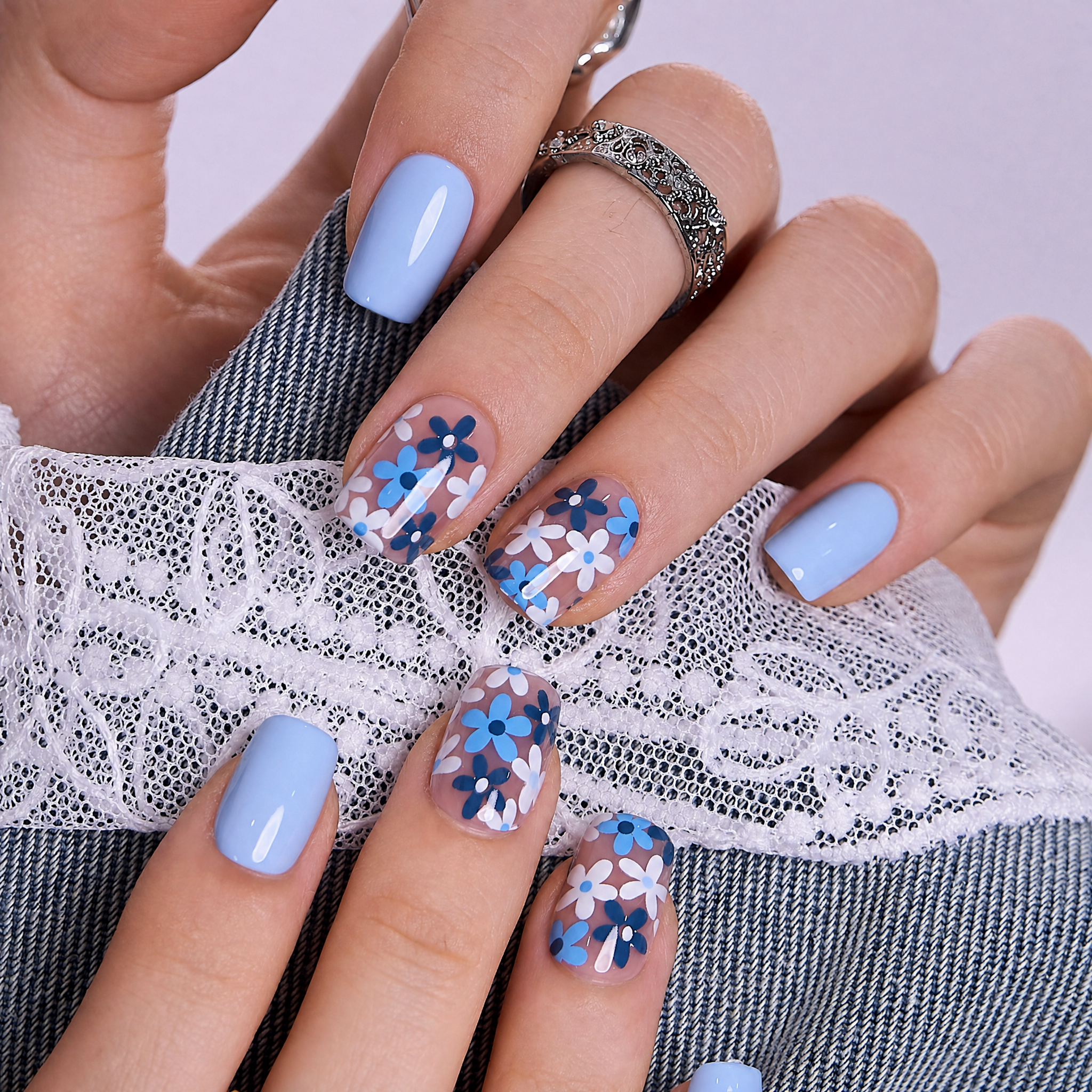 Little Blue short squoval press-on nails worn on a hand