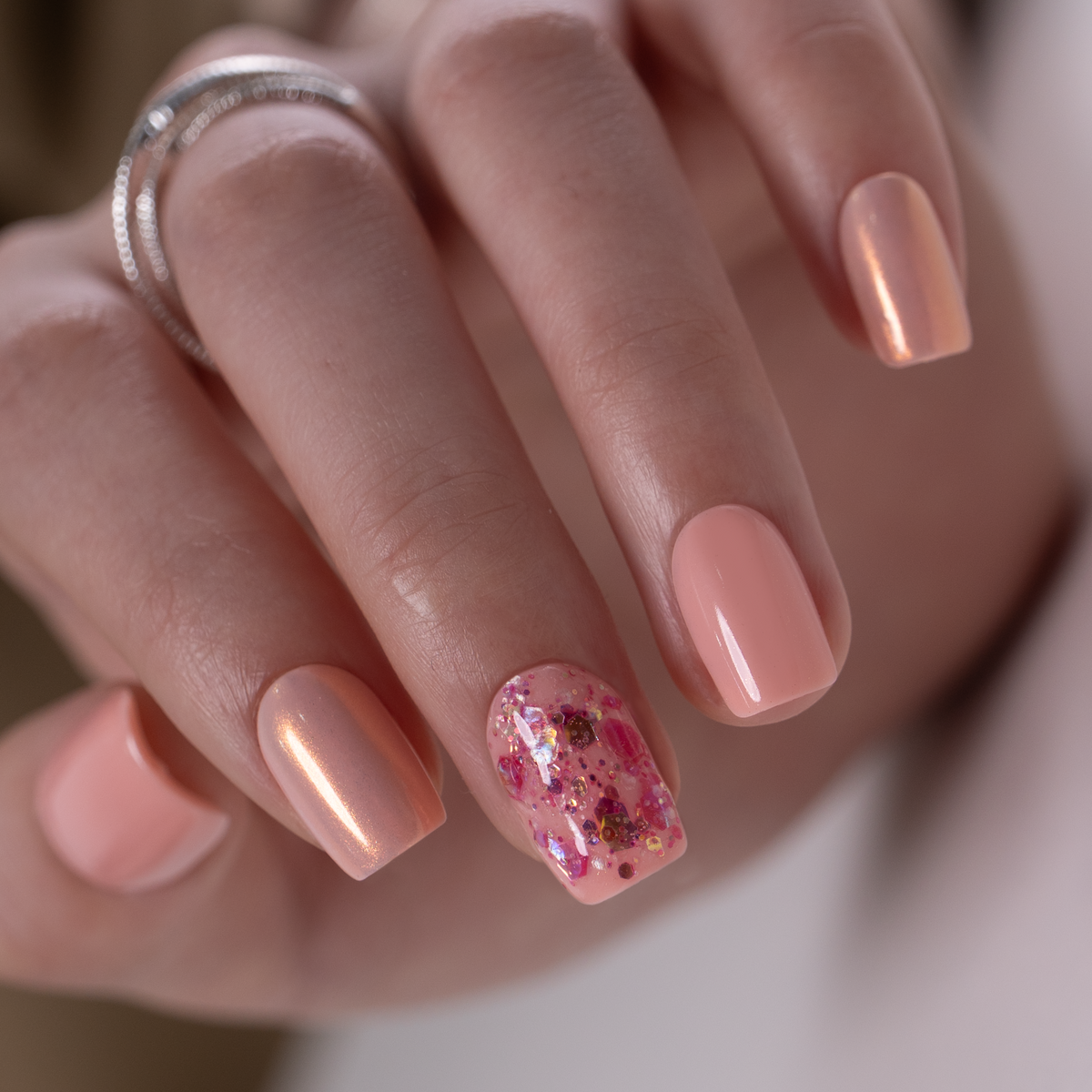 Lovely Pearl short squoval press-on nails worn on a hand
