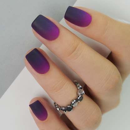Matte Purple short squoval press-on nails worn on a hand