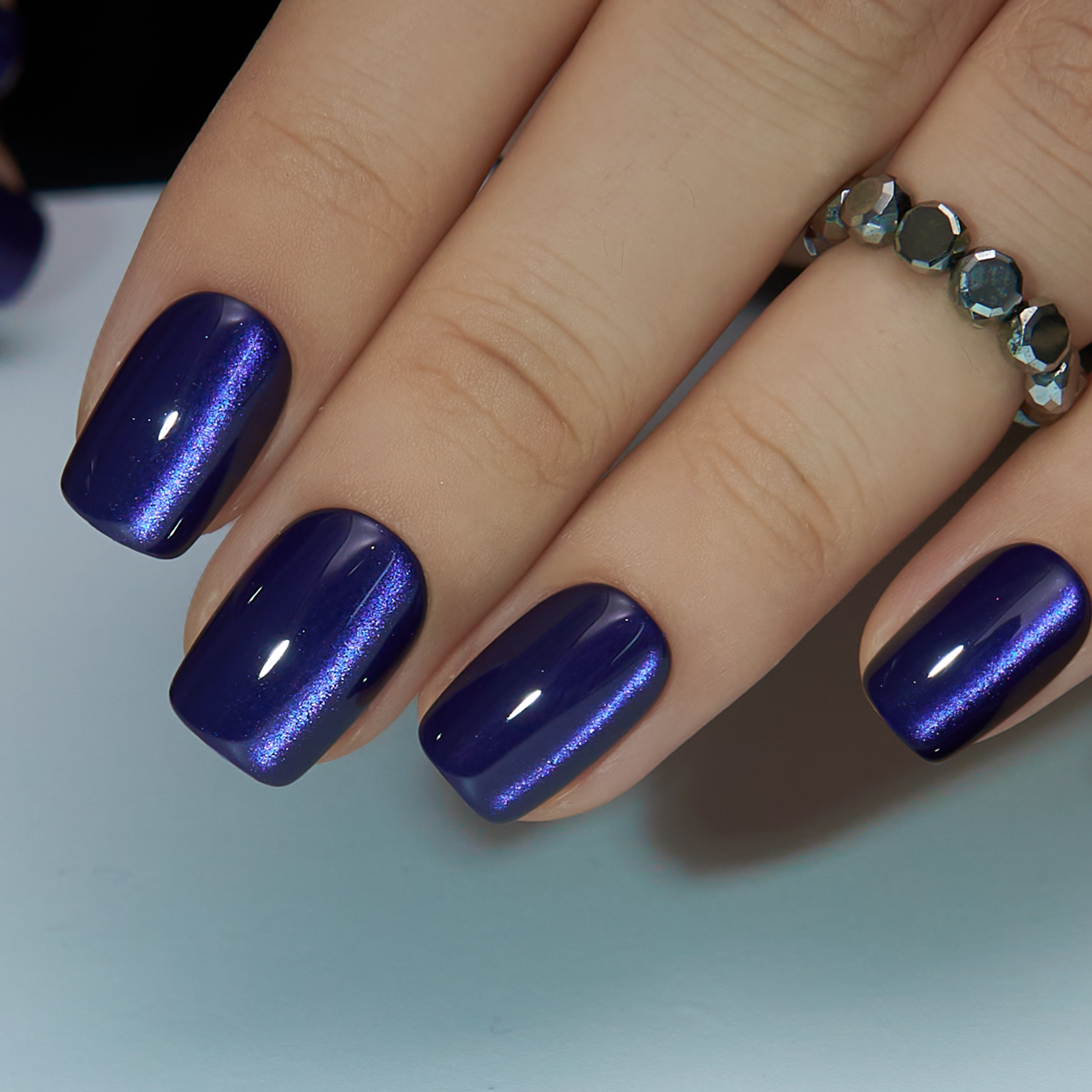 Midnight Aura short squoval press-on nails worn on a hand