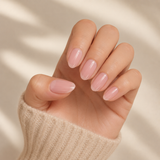 Milky Pink medium almond press-on nails worn on a hand