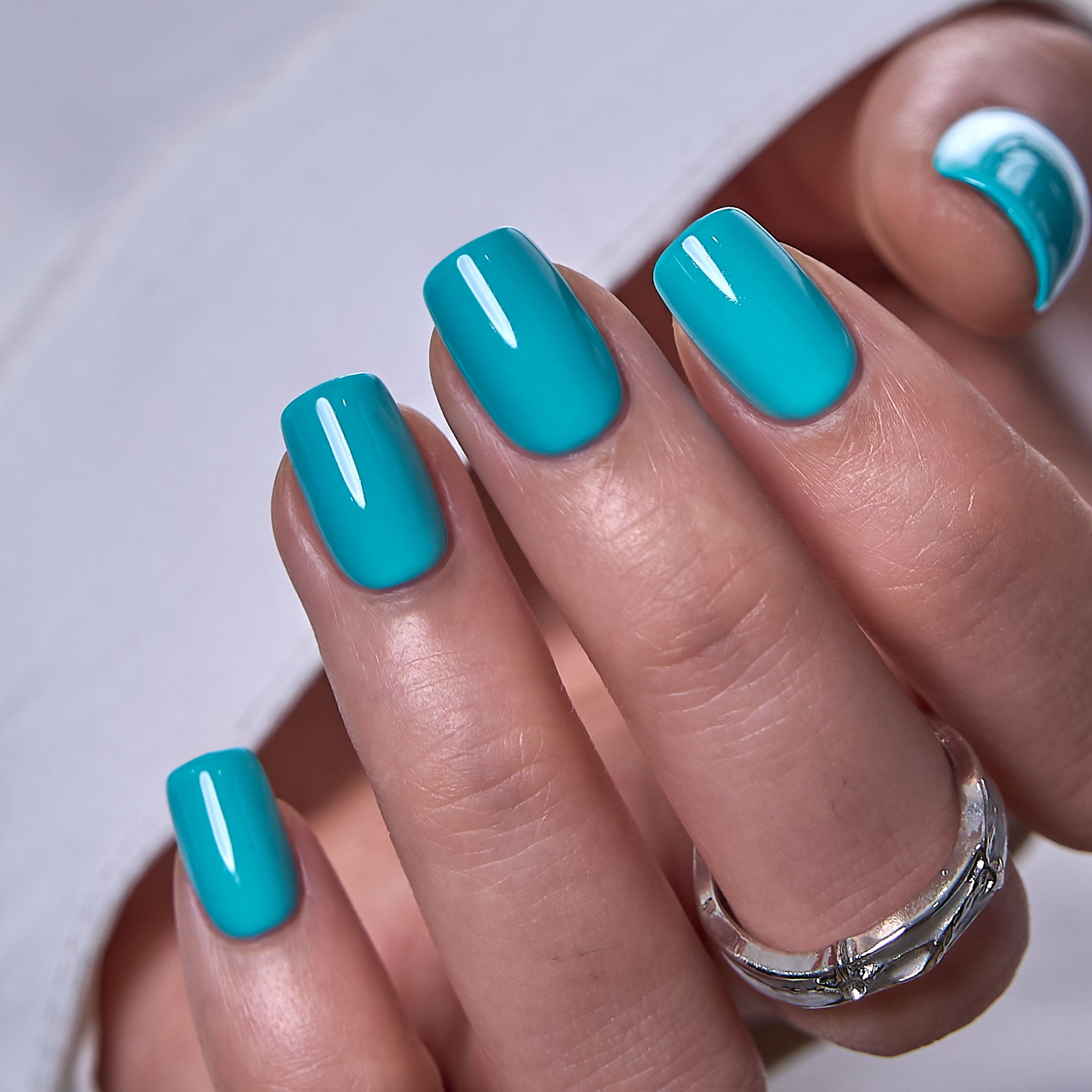 Mint Rush short squoval press-on nails worn on a hand