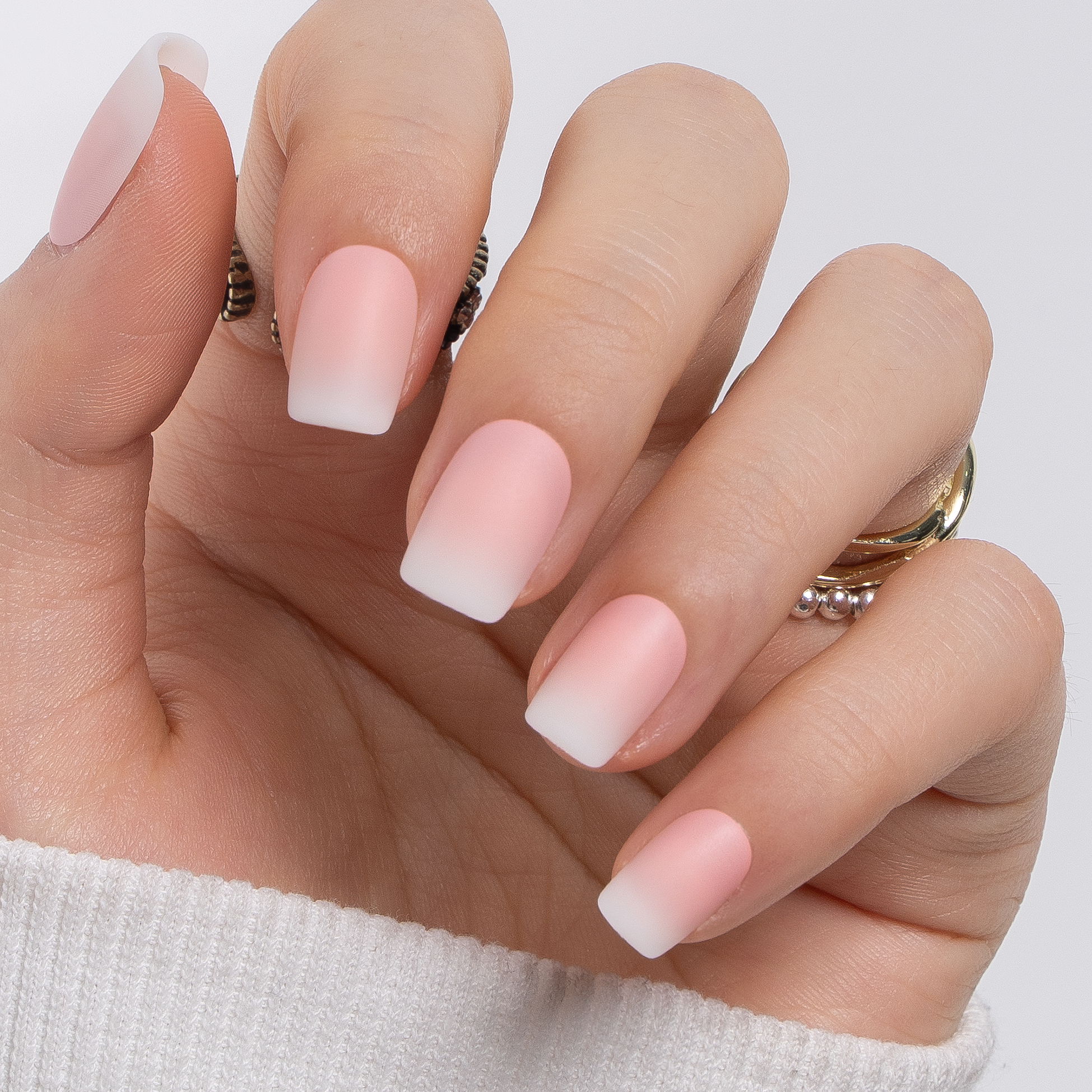 Misty Nude short squoval press-on nails worn on a hand