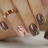 Mocha Luxe short squoval press-on nails worn on a hand