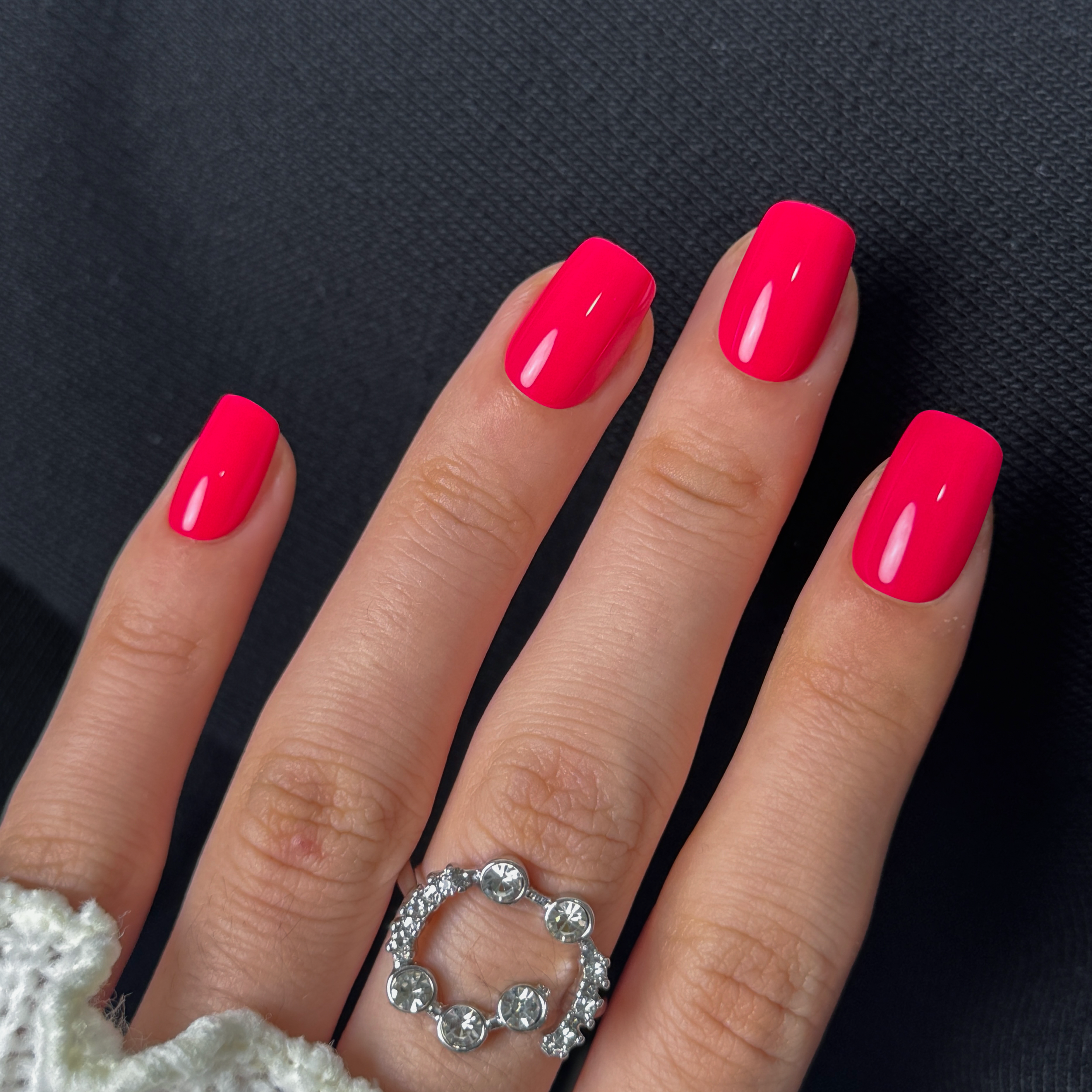 Monochrome Pink short squoval press-on nails worn on a hand