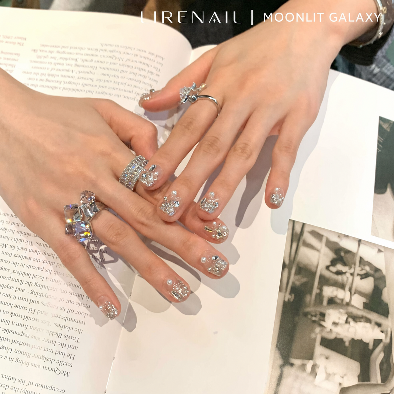 Moonlit Galaxy silver press-on nails styled over a magazine