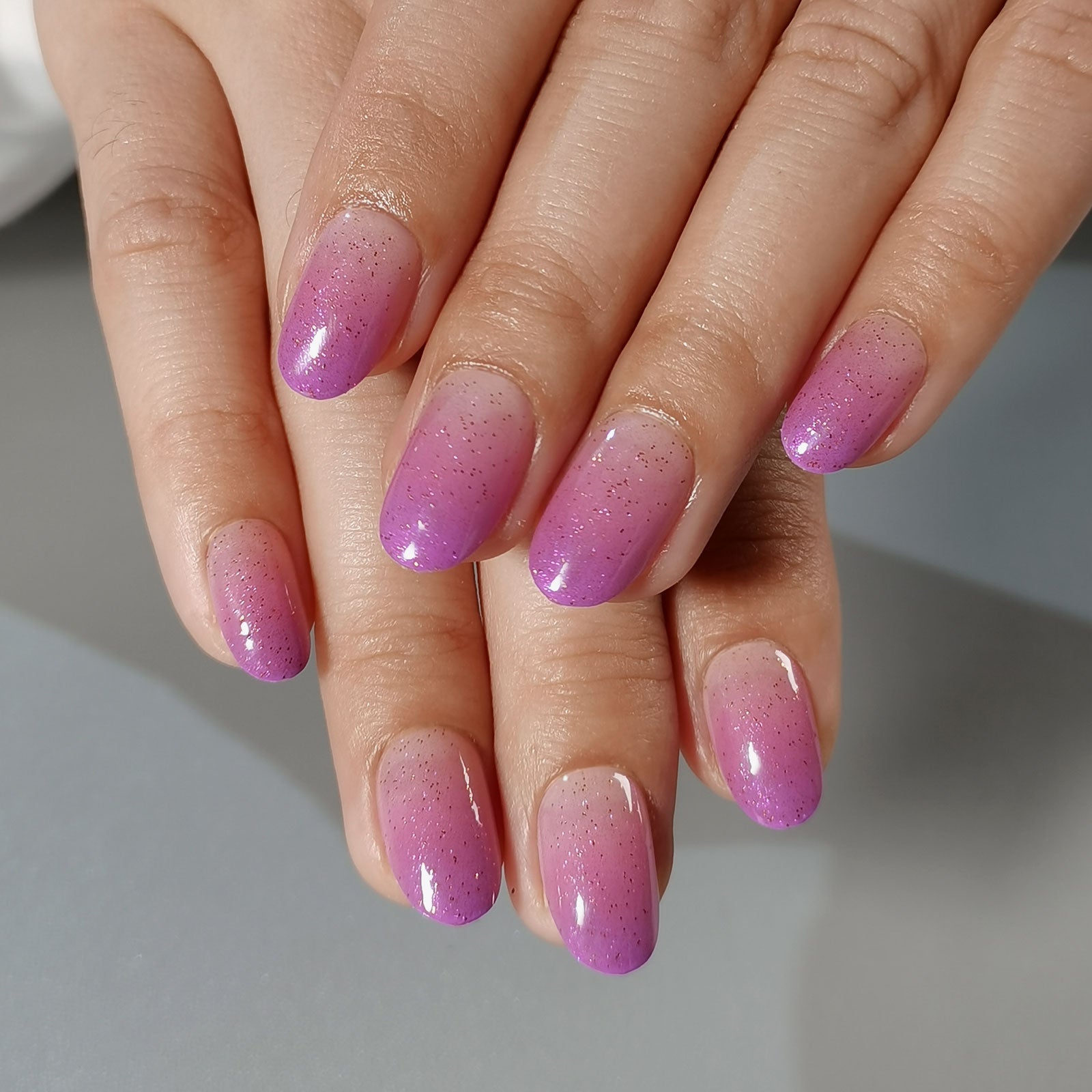Moonlit Lilac short oval press-on nails worn on a hand