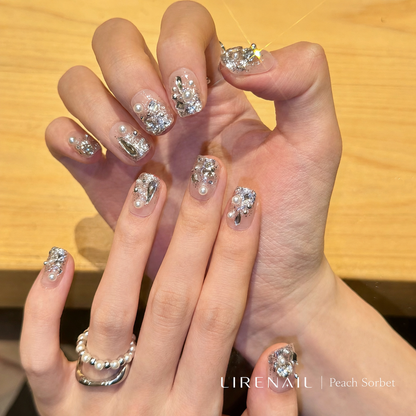 Moonlit Opal press-on nails worn showing pale grey-white base with silver crystal and pearl accents