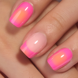 Neon Sunset short squoval press-on nails worn on a hand