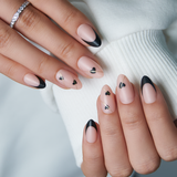 Noir Cupid short almond press-on nails worn on a hand