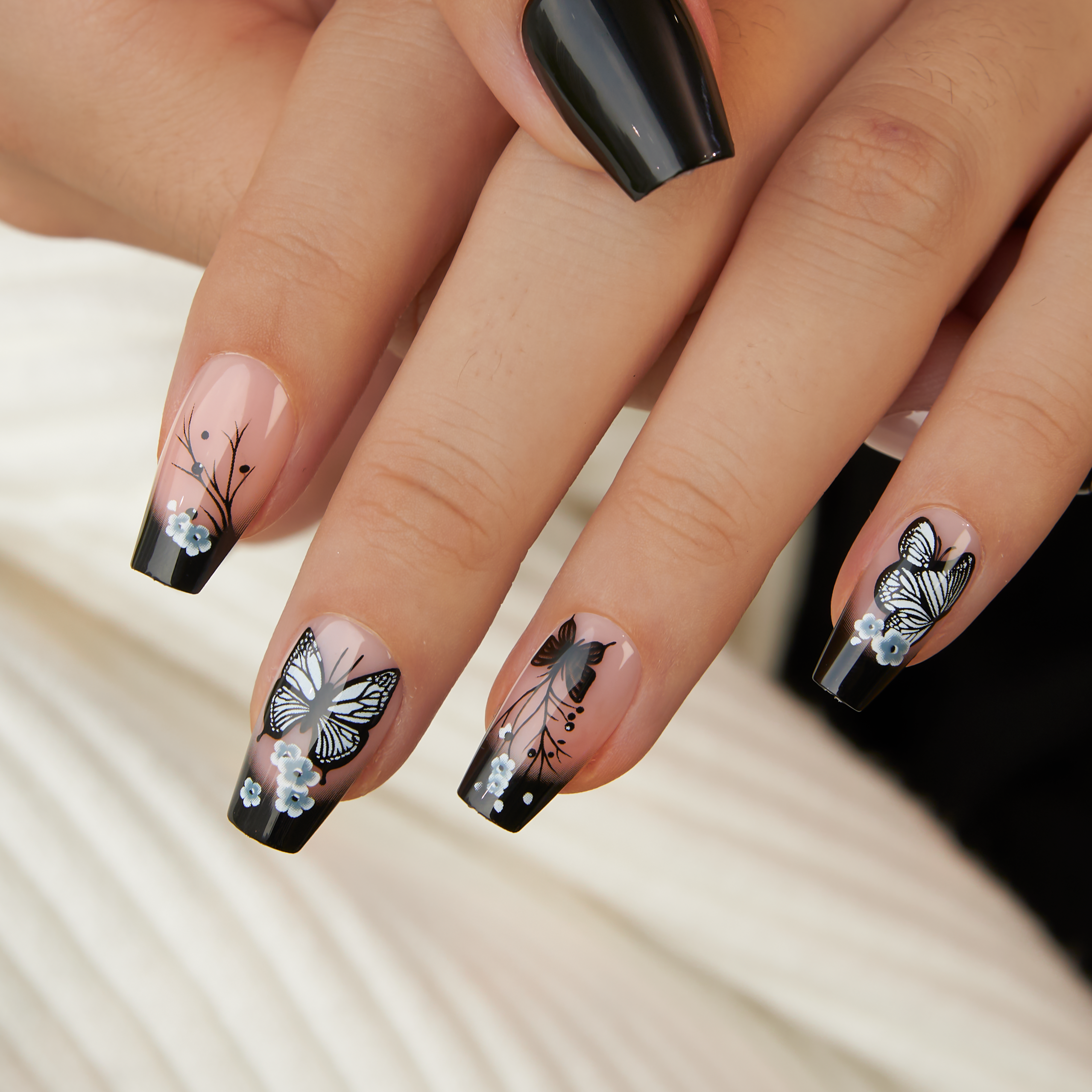 Noir Papillon M Coffin press-on nails worn on a hand